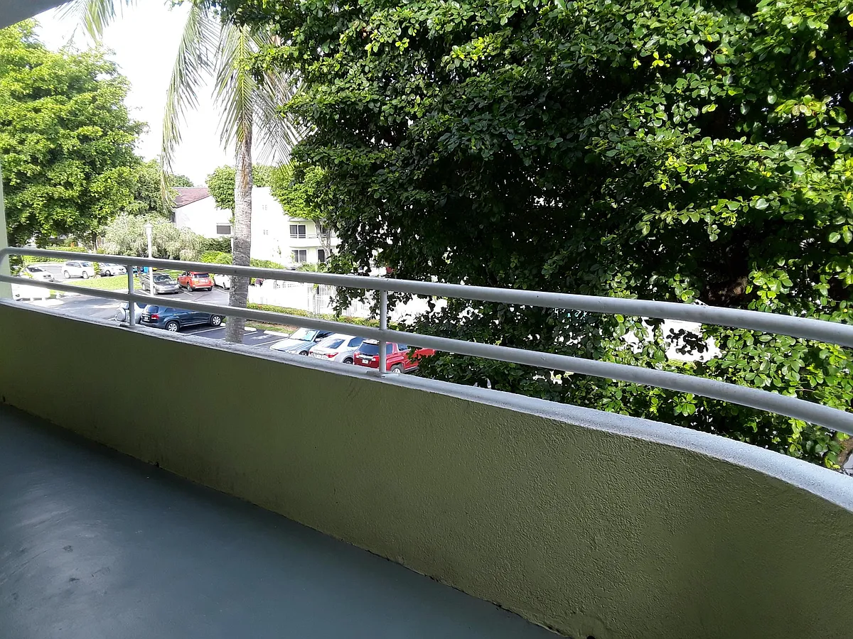 Balcony with view to the pool and parking area. - 10795 SW 108th Ave #301