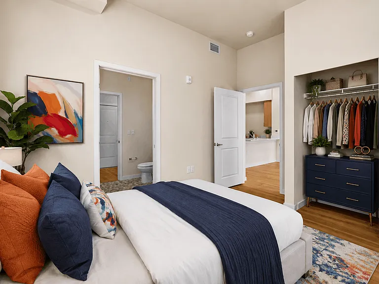 Spacious primary bedroom with a spacious closet and modern finishes at 27 West Apartments.