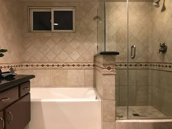Custom tile work with floor to ceiling renovation and in shower speaker