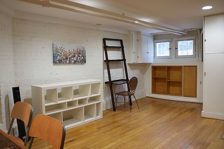 View from kitchenette area toward the front of the apartment. Desk, chair, white bookcase, 2 stools are available for use if desired.