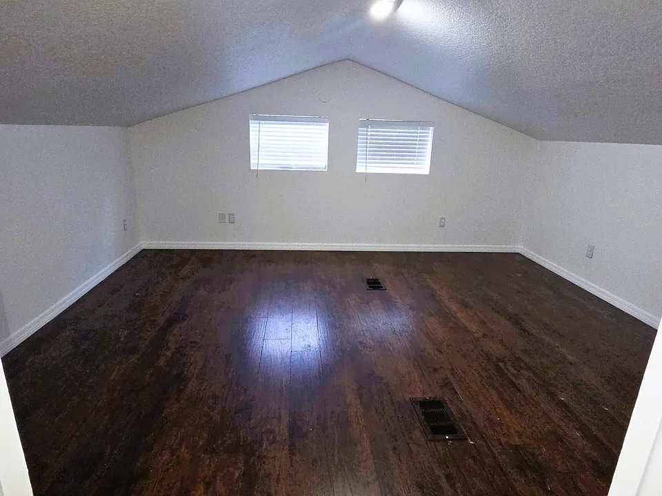 Enjoy a bright bedroom with beautiful window blinds and natural light.