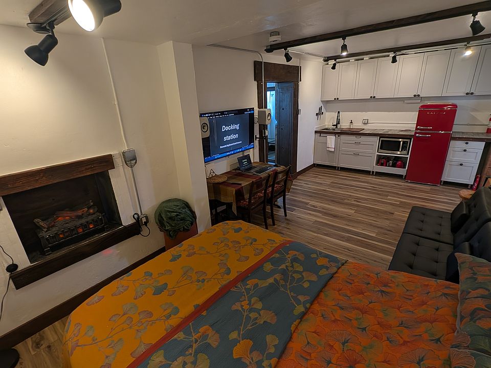 Electric fireplace, adjacent sitting/entertainment area and kitchen area.