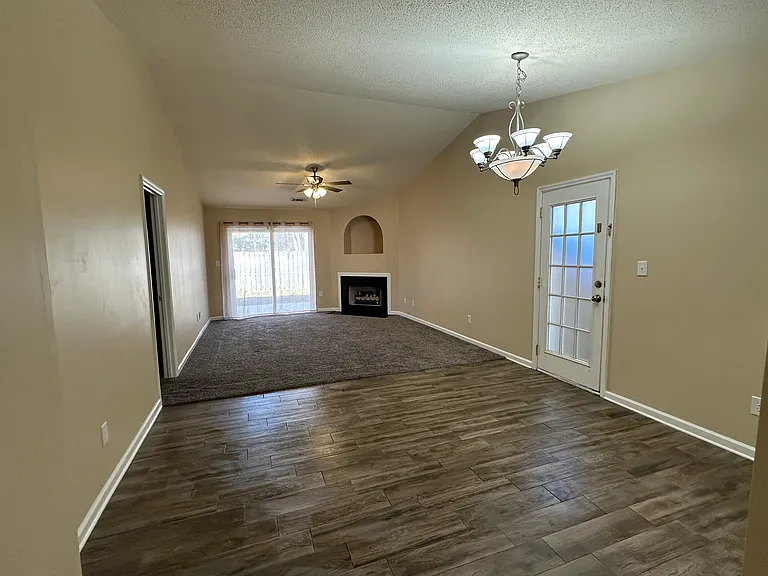 combined living and dining area with sliding glass doors to the backyard. High ceiling.