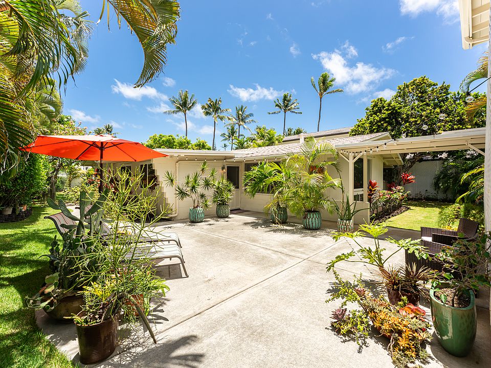 Welcoming entrance to the main home featuring tropical landscaping and spacious outdoor living areas.
