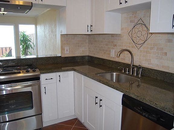 Remodeled kitchen with granite countertops, porcelain tile, and new appliances