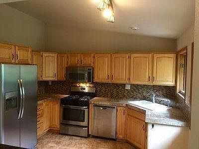 Vaulted ceiling, tile floor and stainless appliances in kitchen