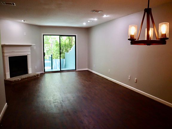 Living/dining room with wood burning fireplace, sliding door to private deck
