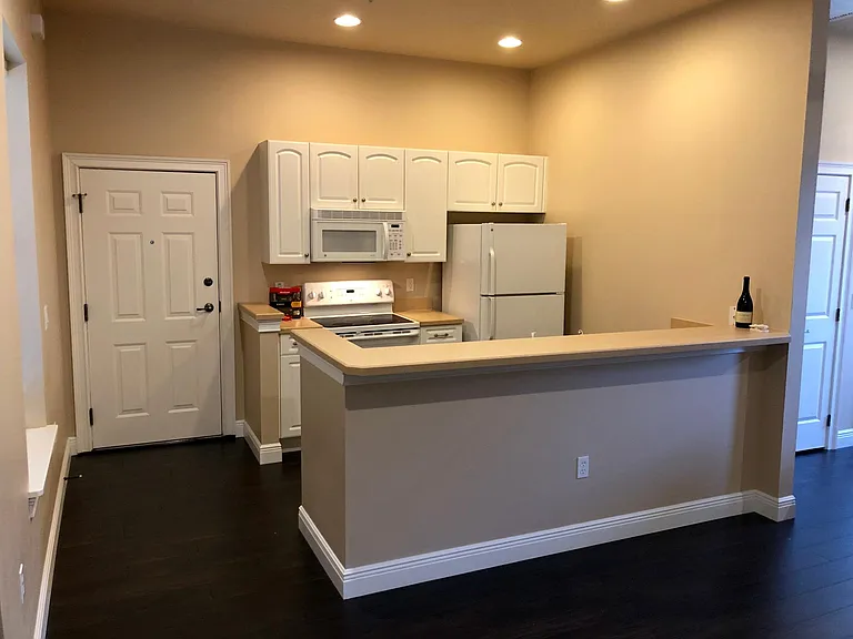 Full kitchen, bright and clean. The bar is a perfect spot for a couple of barstools.