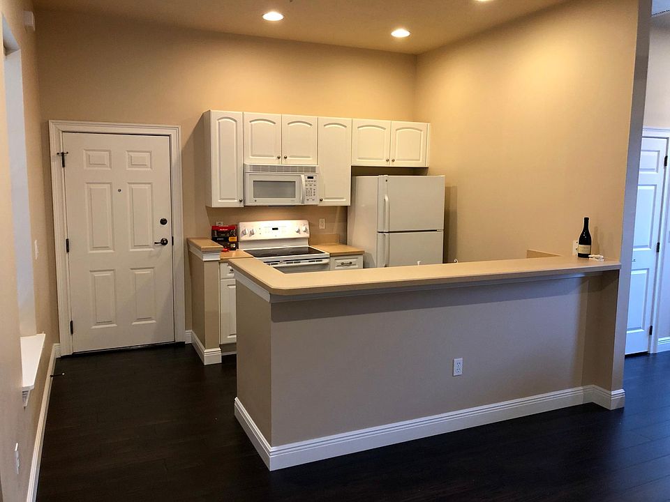 Full kitchen, bright and clean. The bar is a perfect spot for a couple of barstools.