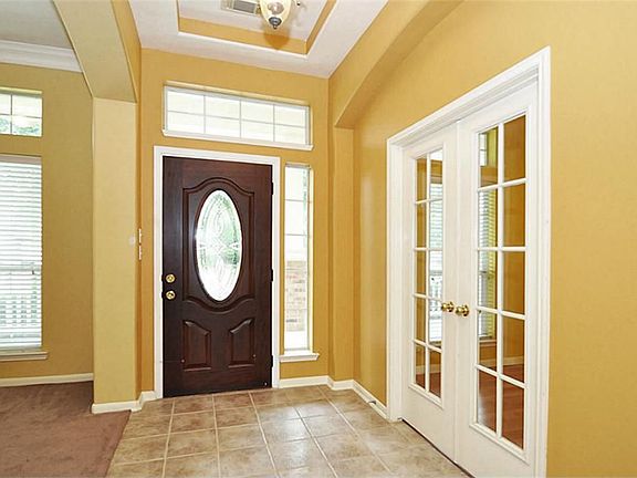 Tiled entry with coffered ceilings and leaded glass front door.
