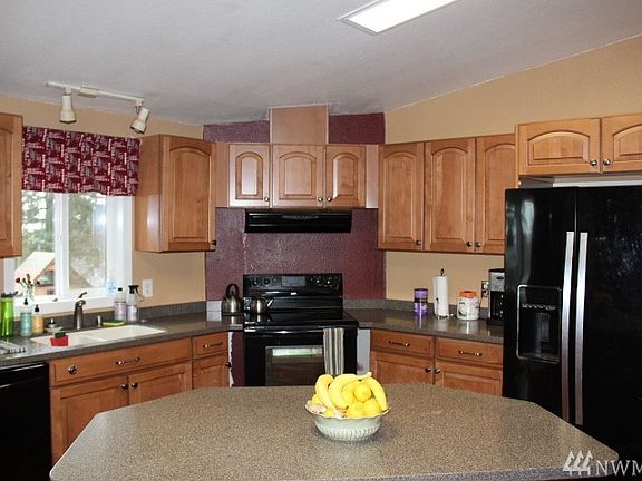 Updated kitchen with corian counters, maple cabinetry, and breakfast bar. 