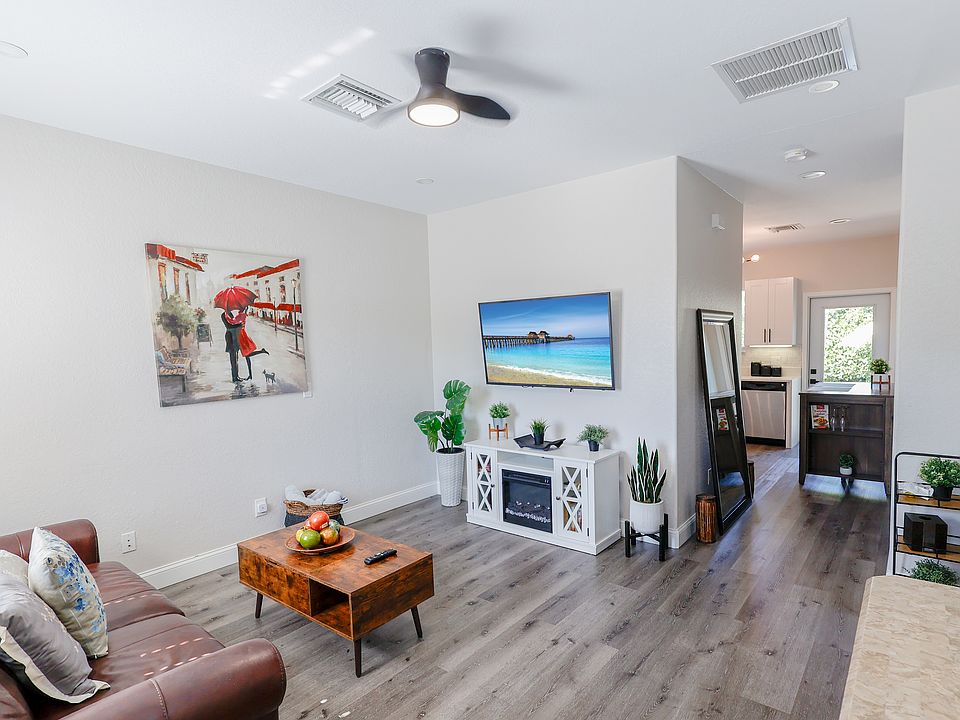 Spacious living room featuring a 60" Smart TV, coffee table/work station and a leather sleeper sofa.
