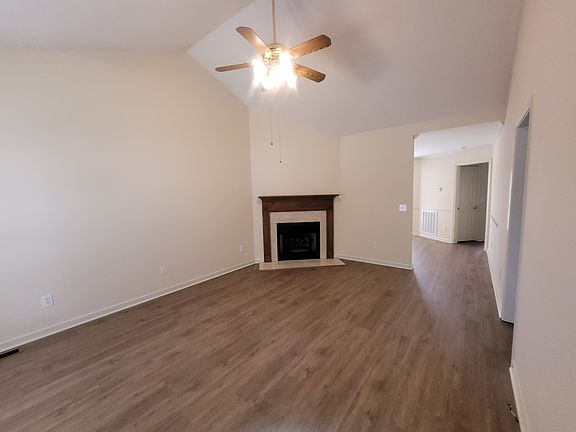 Entering from front door, this is living room. Vaulted ceiling with fan. Fireplace has natural gas logs. Two bedrooms and hall bath to right. Primary suite next right, Dining room back to the left