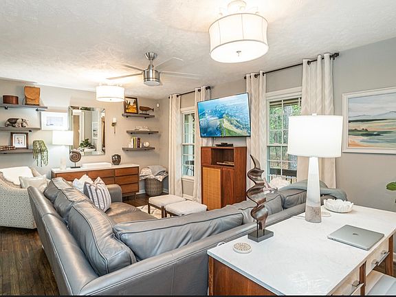 Living Room includes an L-Shaped, comfortable Ethan Allen sofa and large screen (55") TV, movie library, working desk with storage.