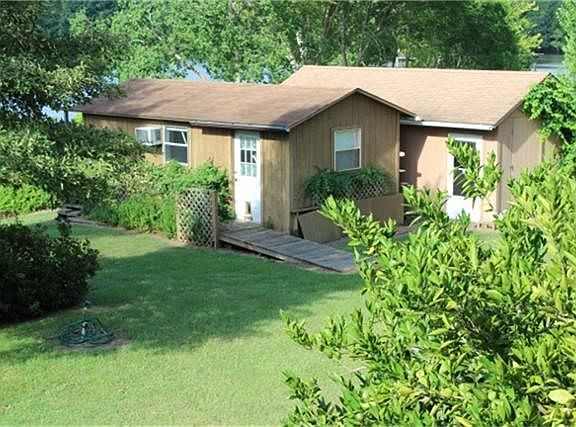 The small building to the left is a one room cabin with full bath with small porch on back over looking the lake