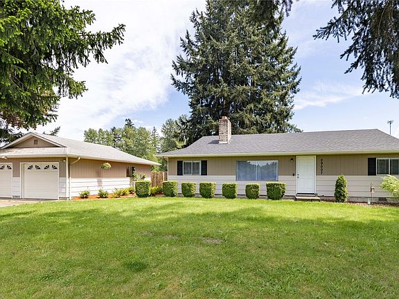 Front of the house with spacious front yard and 2 detached car garage.>