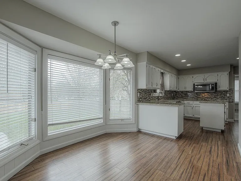 Eat-in kitchen flows directly from the kitchen into the adjoining family room. THE VINYL FLOORING WILL BE GRAY TILE.