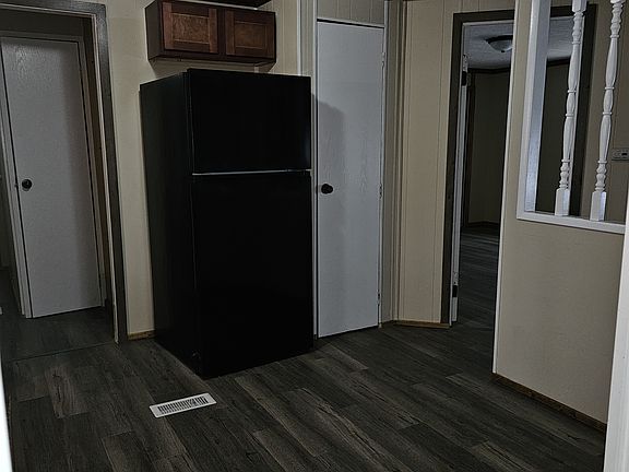 Kitchen area and doorway leading into laundry. Photo taken in doorway leading into kitchen from dining area.