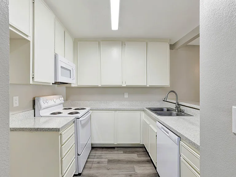 Lake Dianne Apartment Homes Two Bedroom kitchen with white cabinets and appliances.