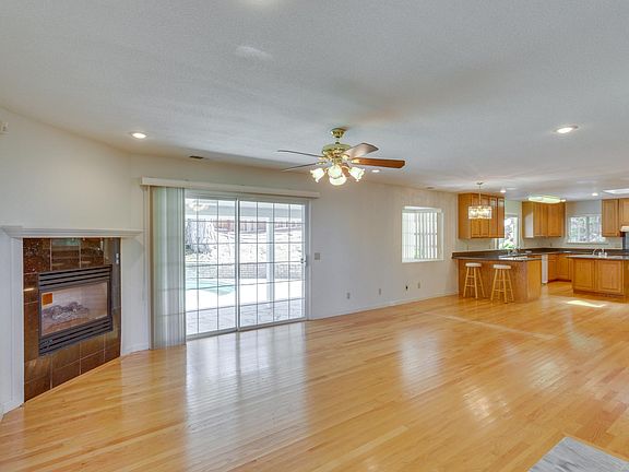 An open-layout family room is located adjacent to the kitchen with a glass sliding door that leads to the large backyard.