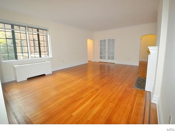 Large living room with working fireplace, large closet with french doors and refinished hardwood floors.  The room is 21'-11" x 15'-7".