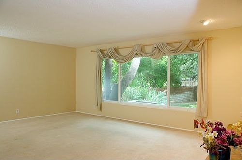 Living room has picture windows overlooking gardens
