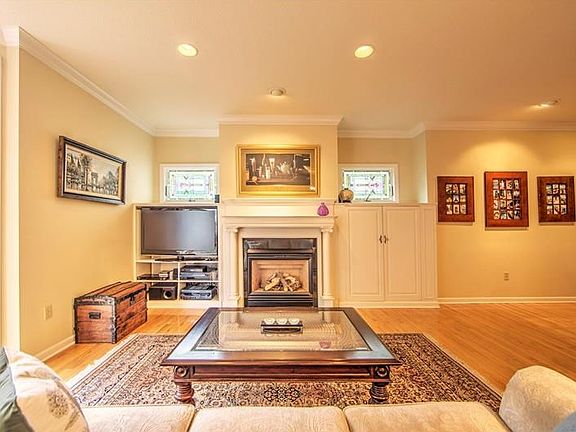 Grand living room with gas log fireplace, built-in cabinetry, stained glass windows...