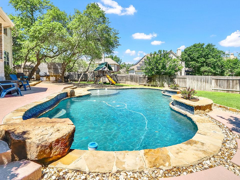 Backyard oasis with shade trees, large flagstone patio, and playscape