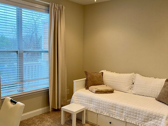 Second bedroom with day bed that can extend to a double. Viewed from the entry door. Desk to the left. Second bathroom and closet are to the right. Window onto the deck.