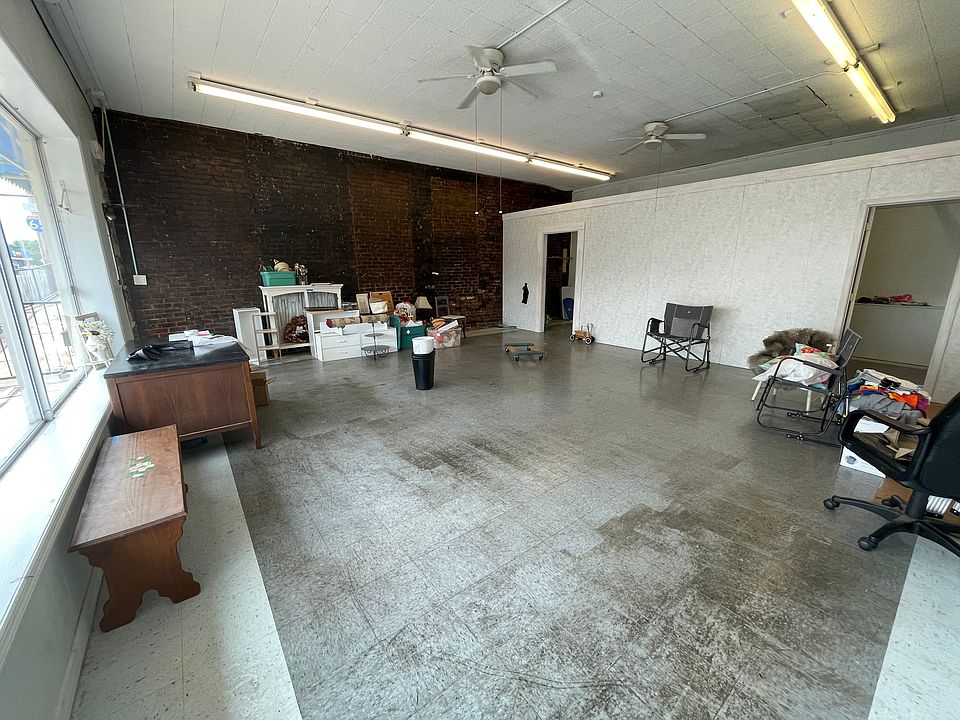 Main space with large windows and exposed brick. Last tenant put up the wall and can be removed to tenants preference.