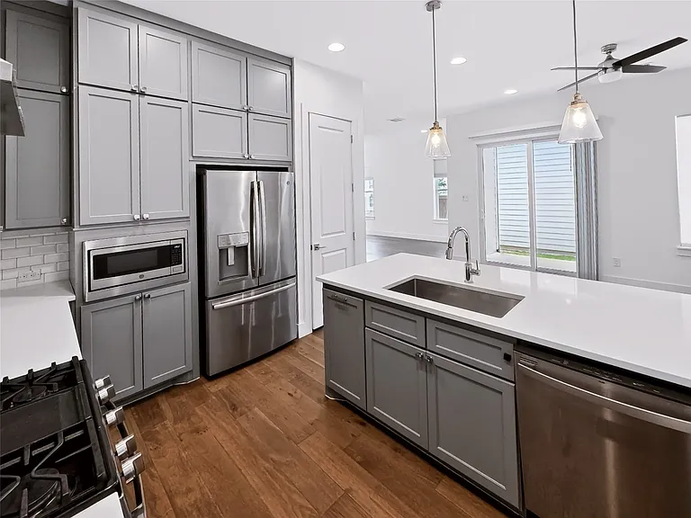 Contemporary kitchen featuring an island with an undermount sink and stainless steel appliances