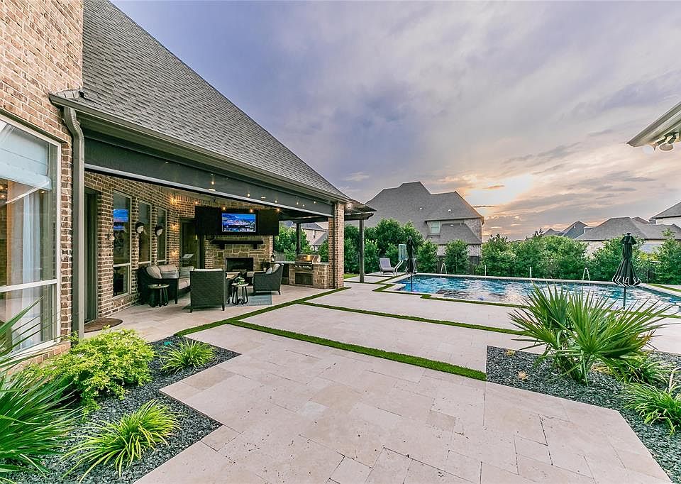 Back yard with view of covered patio with electric screens that come down with a push of a button.