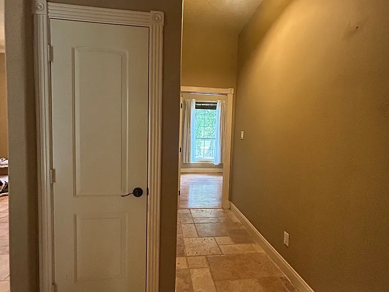 hallway from front bedroom to living room with linen closet