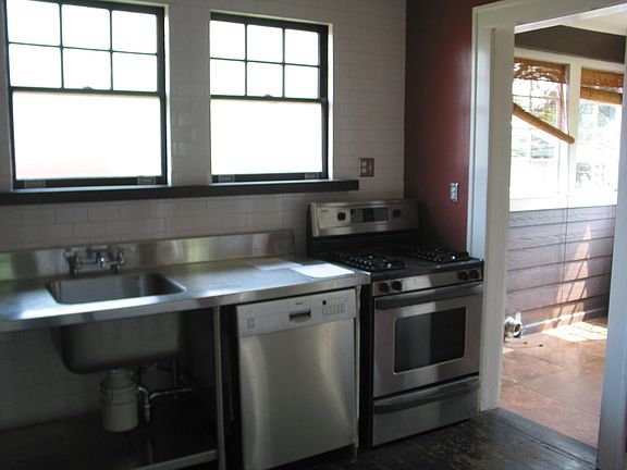 Subway tile on the wall behind the stainless sink.