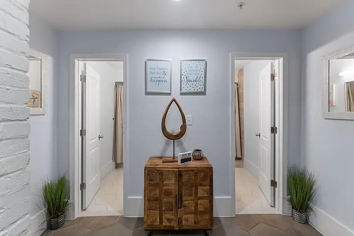 Welcoming hallway nook with accent console, decorative wall art, and convenient access to adjacent rooms and bathrooms.