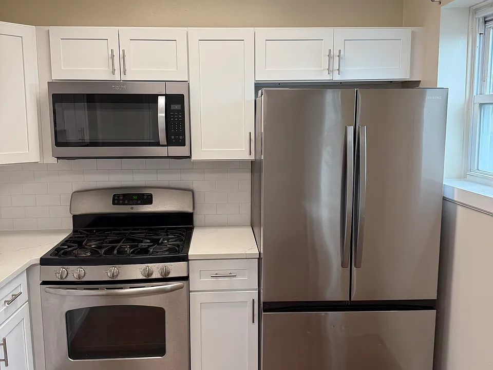 Stainless steel refrigerator, gas range, and built-in microwave included.