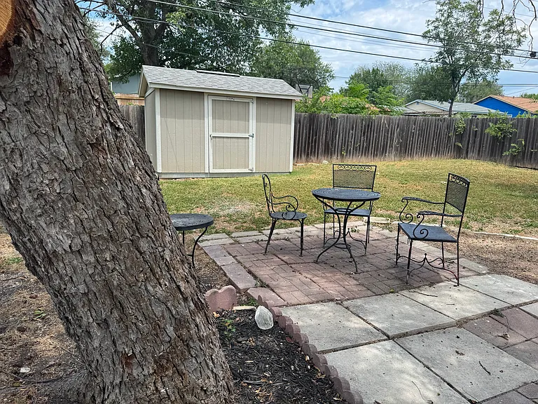 Charming, tree-shaded backyard patio is the perfect outdoor spot in this spacious backyard.
