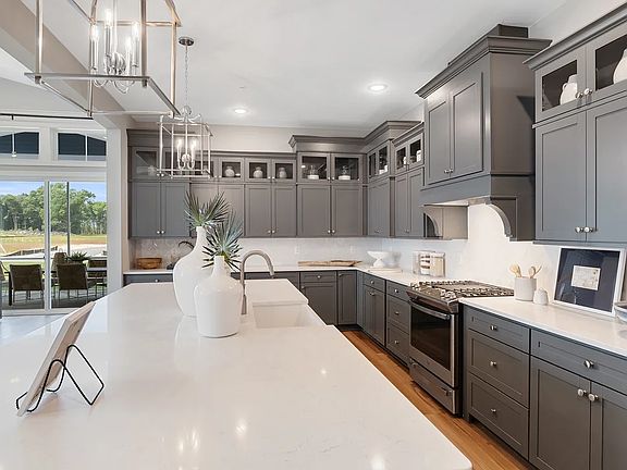 Kitchen with island, pendant lighting and glass-front upper cabinets