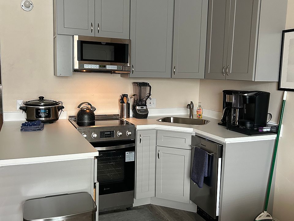 Kitchenette with oven, microwave, stovetop, dishwasher.