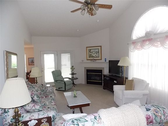 Spacious 21 X 14 great room with cathedral ceiling, gas log fireplace, and palladium window.