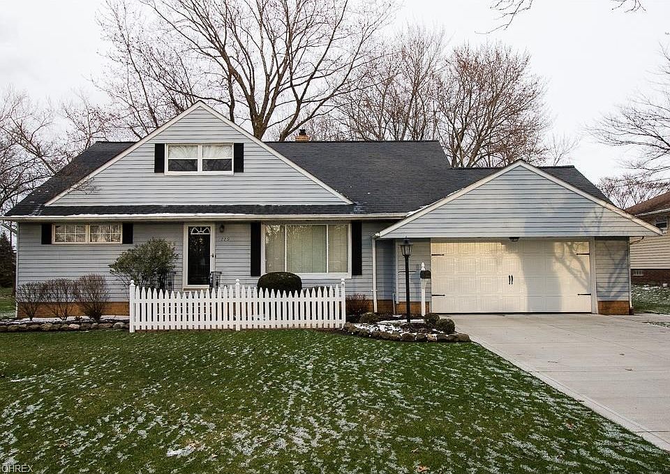 Pristine front yard with newer concrete driveway and garage door.
