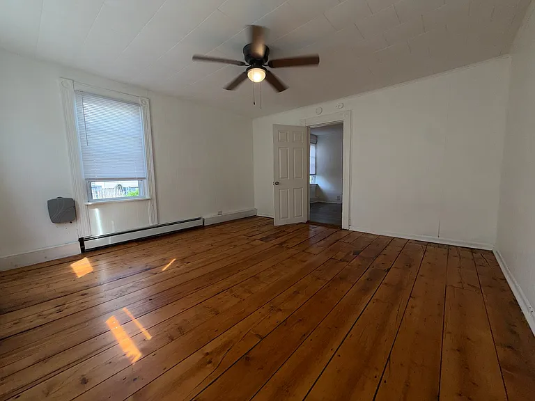 Bedroom #1 with ceiling fan and original floors