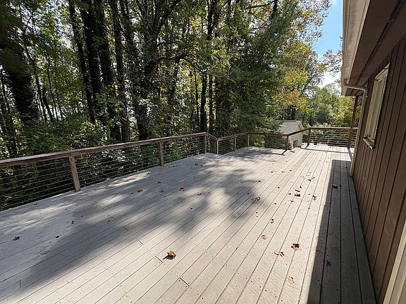 Huge deck in the woods with a covered area.