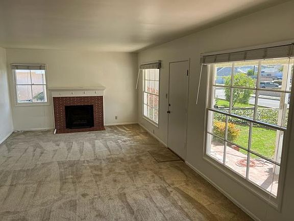 Spacious living room with fireplace, large windows, and lots of natural light.