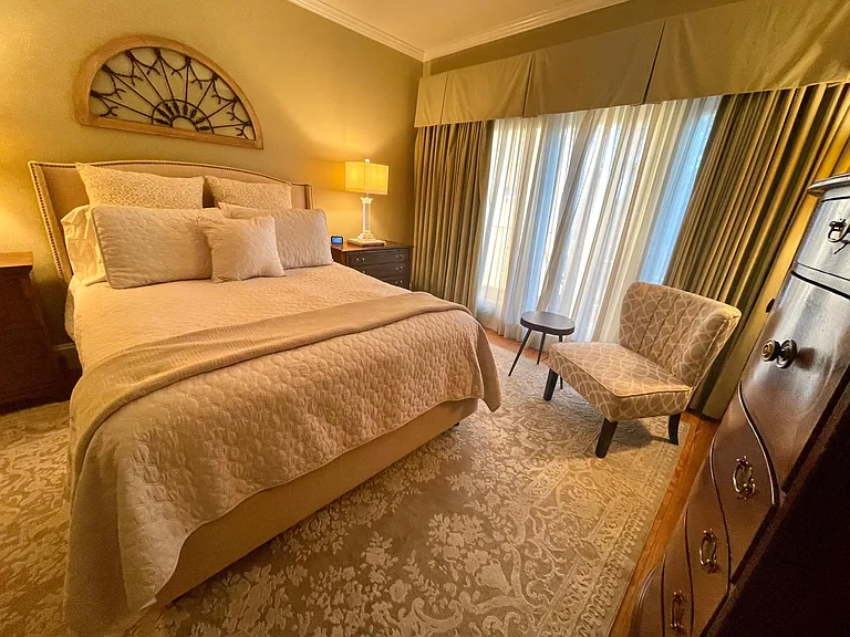 Primary bedroom with queen bed, TV & balcony.