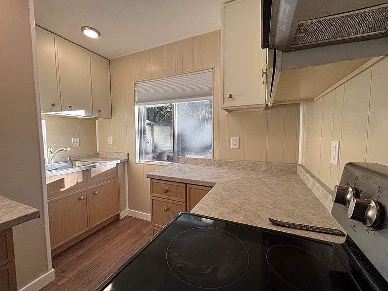 NEW kitchen with window looking out at apple, evergreens and oaks trees, stove, frig, microwave, new counters and cabinets