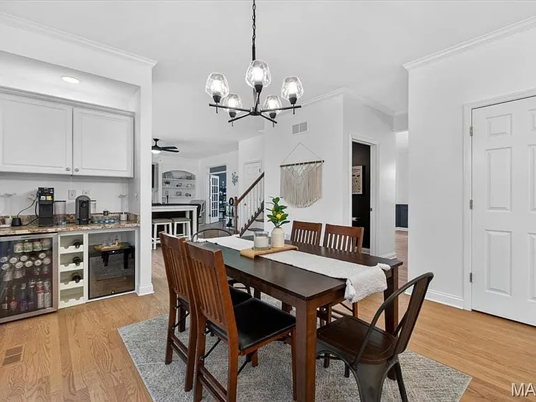 Bright dining area featuring wood-finish flooring and a contemporary chandelier