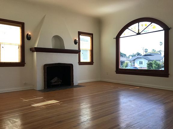 Original tiles/hearth on gas fireplace (restored and fully functional), high coved ceilings, large arched window, and updated lighting
