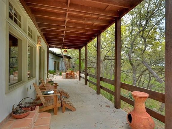 Covered back porch looking through tree tops over Wimberley Valley.