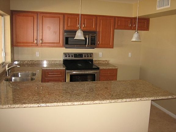 slab granite, pendant lighting, undermount sink, and recessed lighting all new